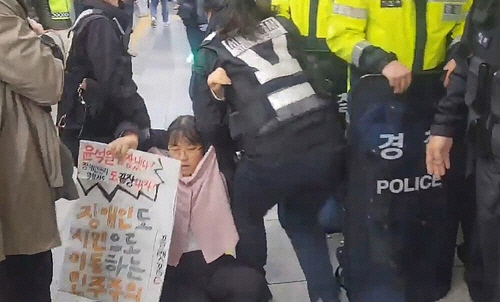 25일 오전 서울 지하철 4호선 혜화역에서 출근길 선전전을 벌이던 전국장애인차별철폐연대(전장연)가 지하철 당국에 의해 다시 강제 퇴거당했다. [연합뉴스]